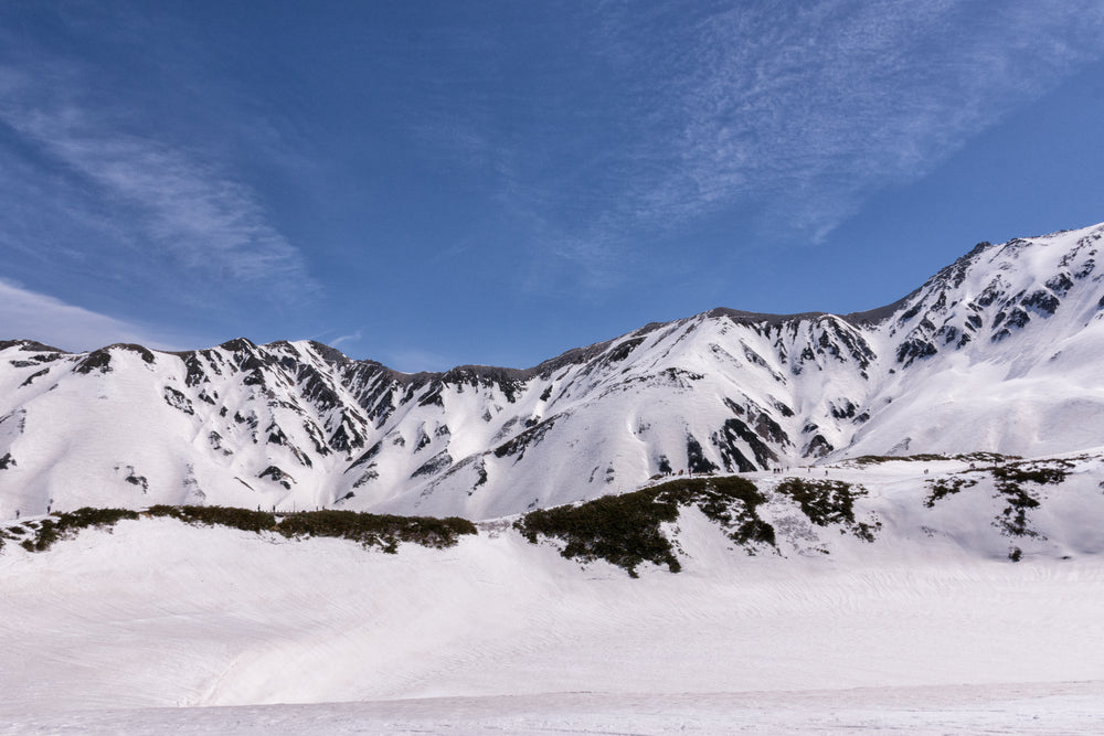 hikers traversing snowy mountain trail