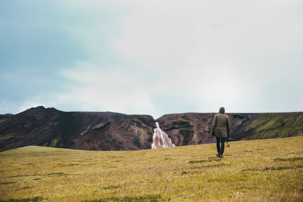 hiking green field near glacier