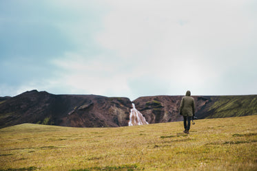 hiking green field near glacier