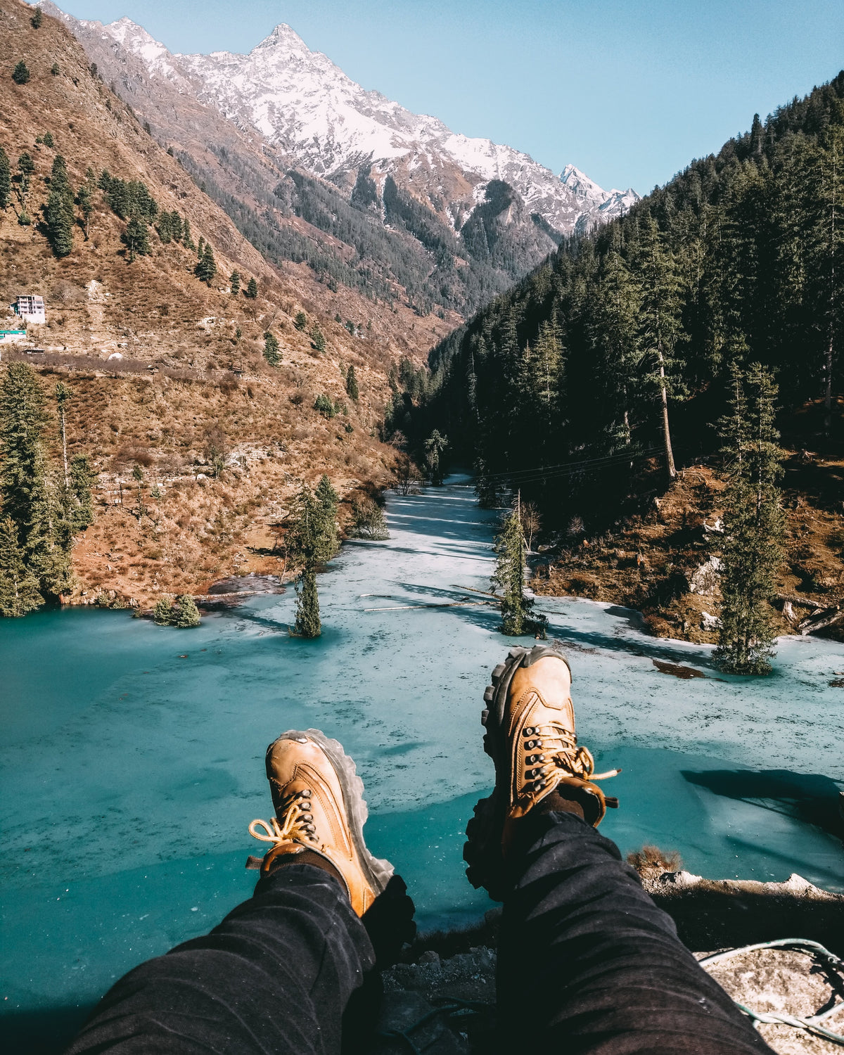hiking shoes reach out to a cold aqua lake and rocky mountians