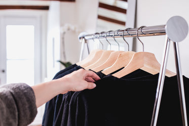 holding a sweater on a clothing rack