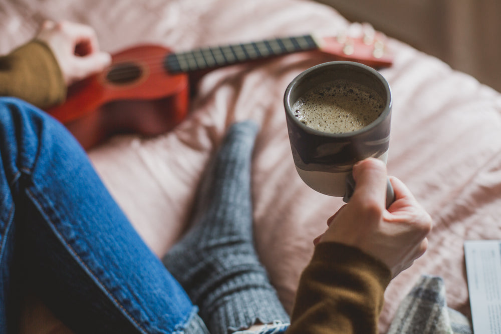 holding coffee in bed
