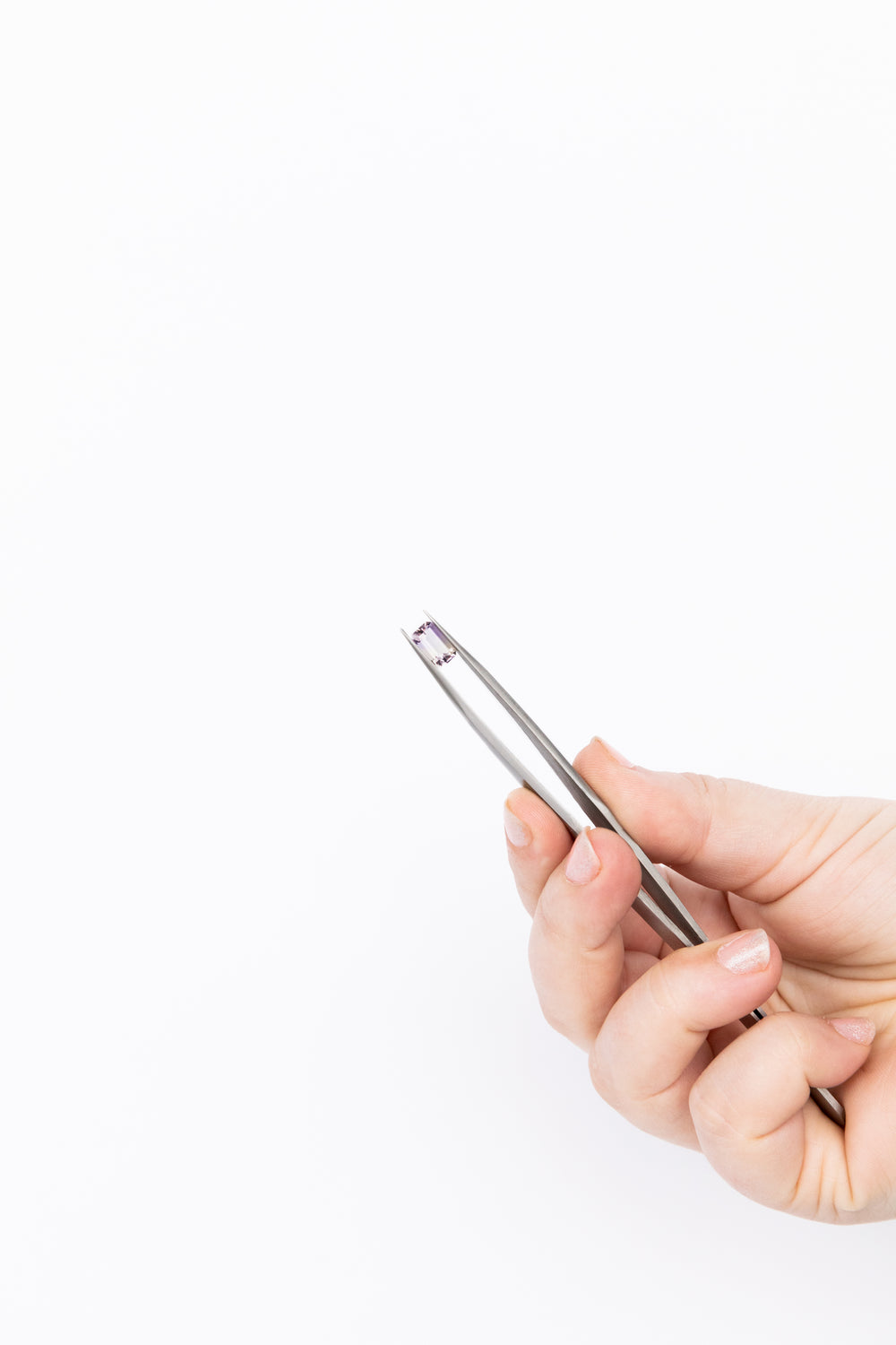 holding gemstones with tweezers