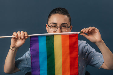 holding pride flag in front of face