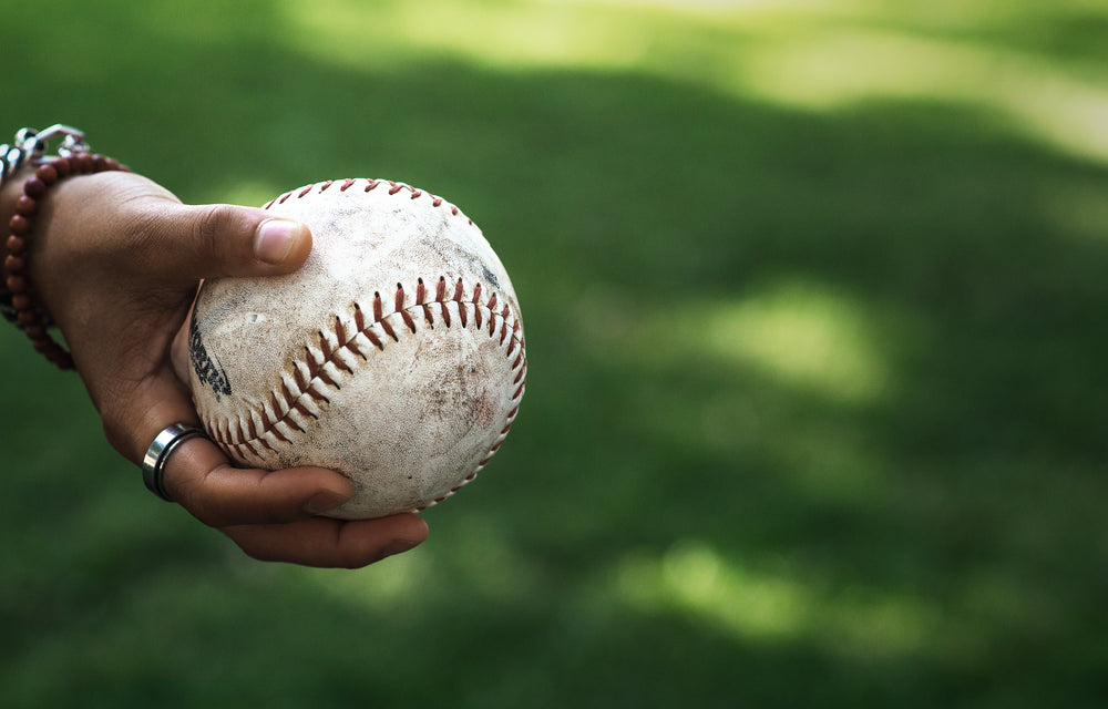 holding softball in grassy park