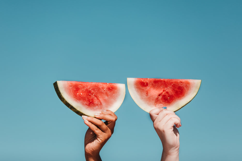 holding watermelons in the sun