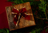 holiday gift on a red table covered in cedar