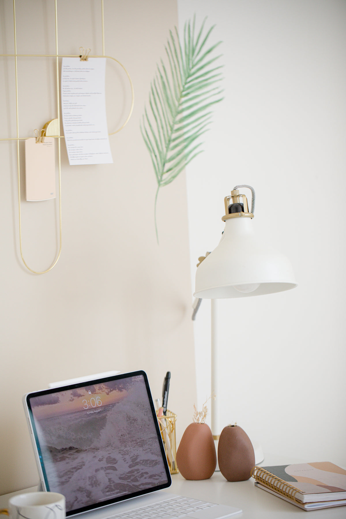 Laptop, lámpara y cuadernos en tonos beige