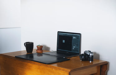 home office with a laptop and film camera on wooden table