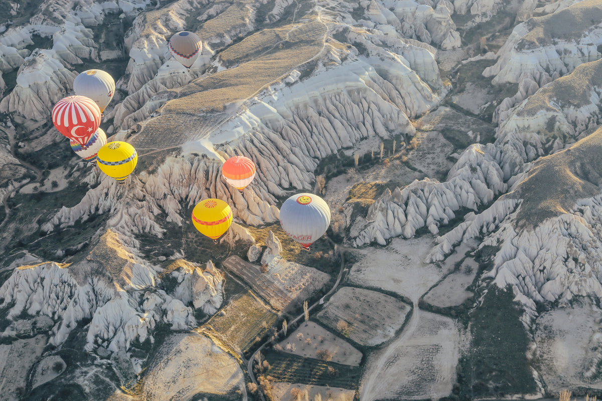 hot air balloons over rocky landscape