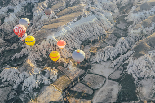 hot air balloons over rocky landscape
