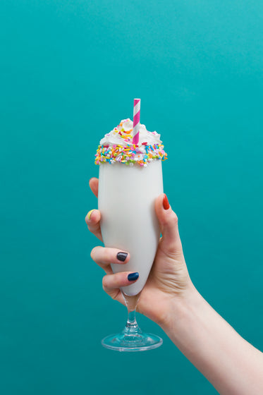 ice cream milkshake in hand on teal