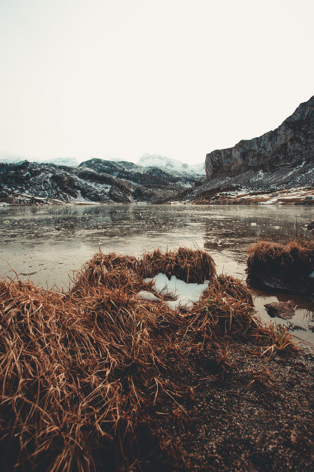 icy lake before snowcapped mountains