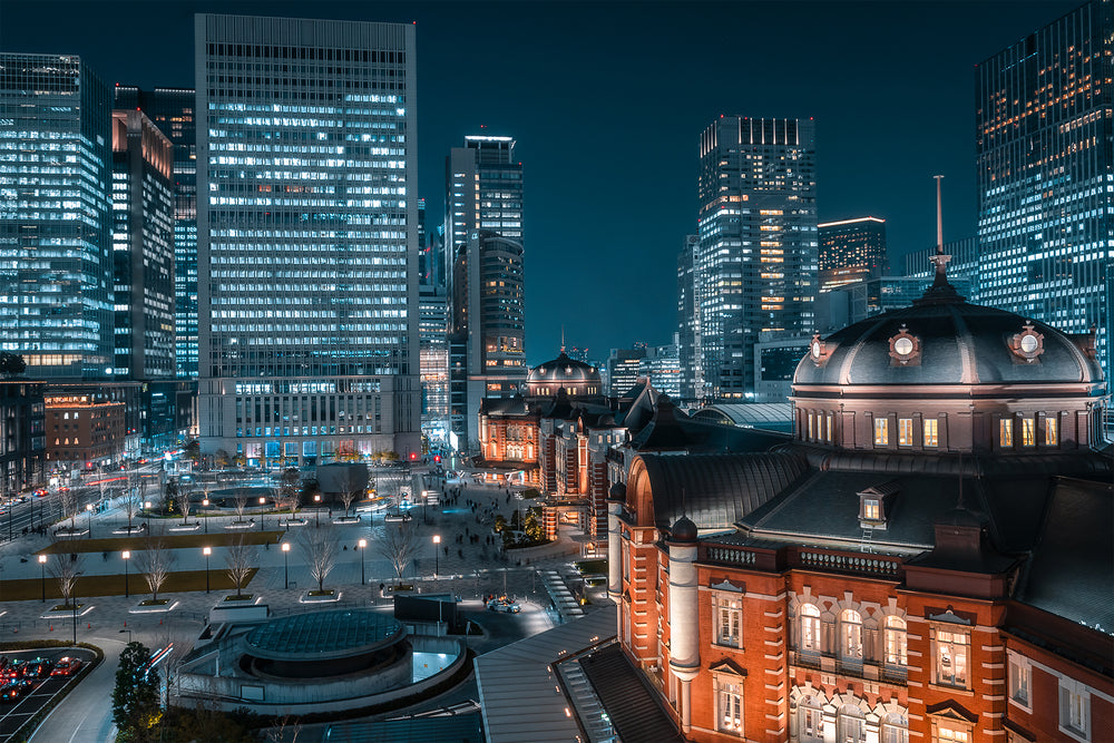 illuminated city building surrounded by high rises