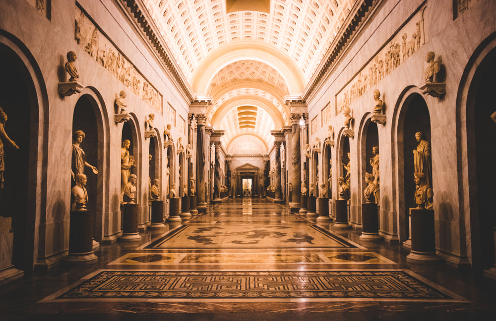 illuminated corridor lined with statues