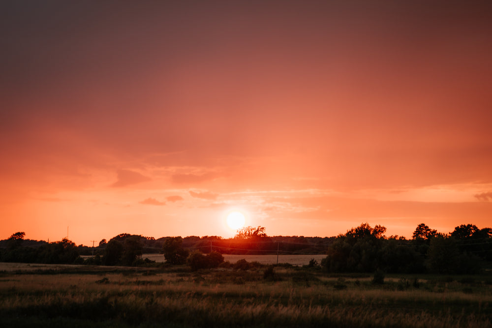 intense red sunset over fields