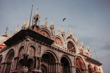 intricately carved building with a bird flying overhead