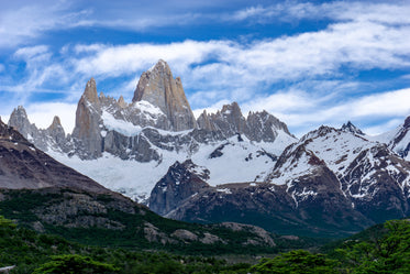 jagged mountain peaks above lush forest below