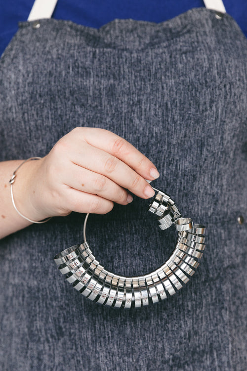 jeweler holds ring-sizer