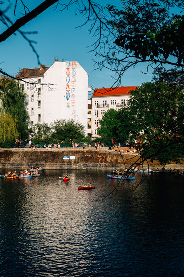 kayaks float in river with buildings behind it