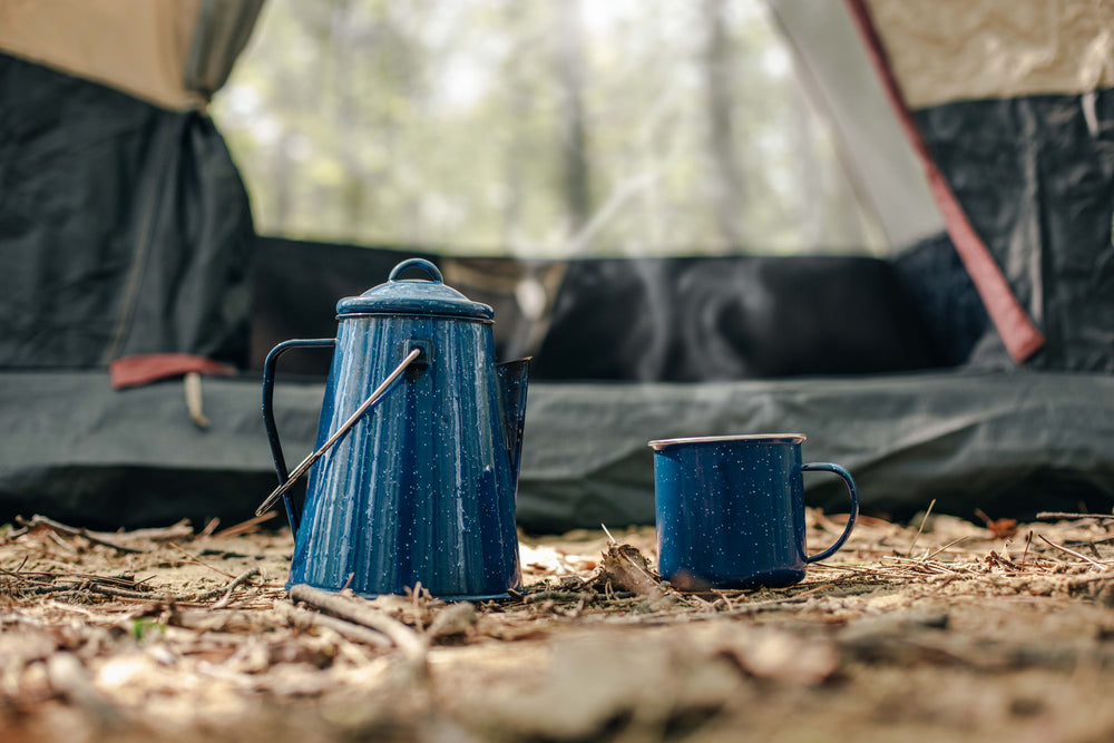 kettle and cup in front of tent