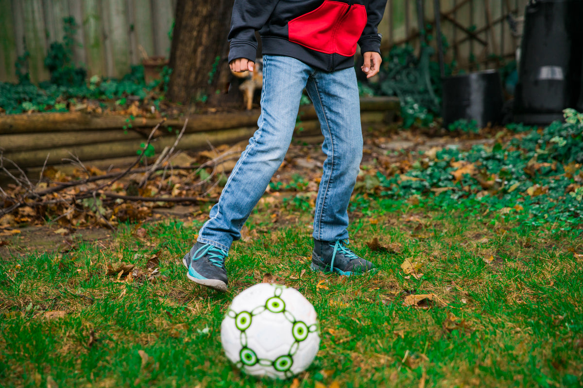 criança joga futebol