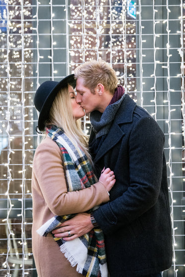 kissing couple with holiday lights