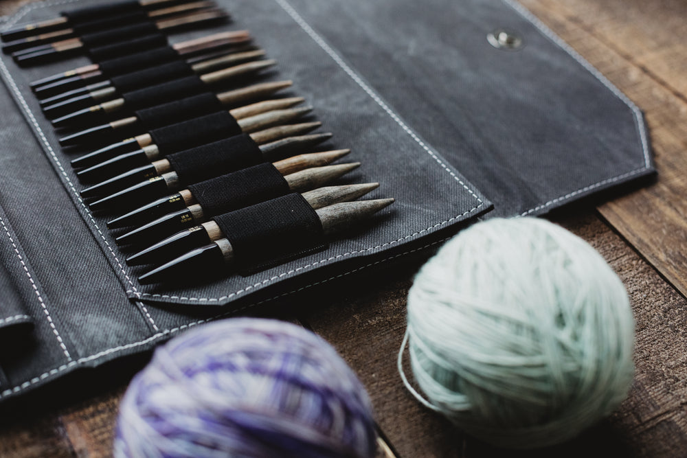 knitting needles and yarn on a wooden table