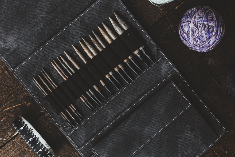 knitting needles neatly organized in their tool belt