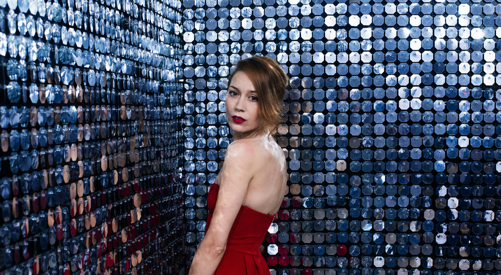 lady in red dress turns away from her wall of mirrors