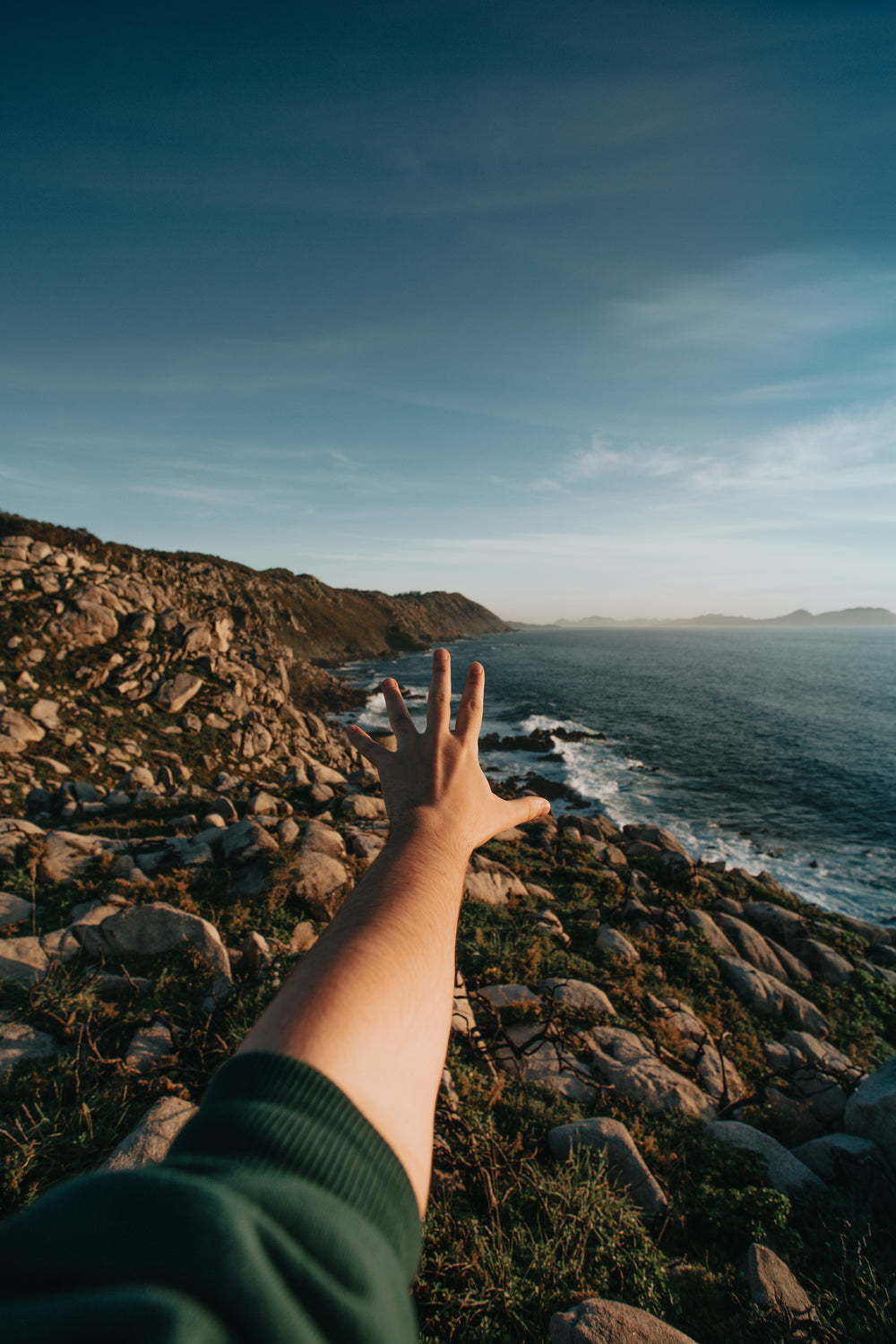 landscape of a rocky shore with a hand reaching out to it