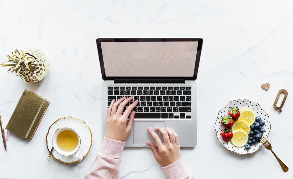 laptop sobre a mesa e chá ao lado