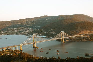 large bridge connects two green hills