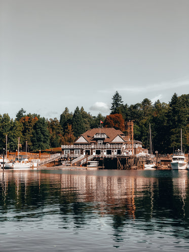 large brown and white buildings by a still lake