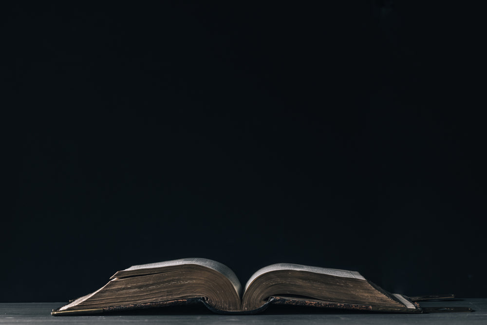 large leatherbound book on a bare table