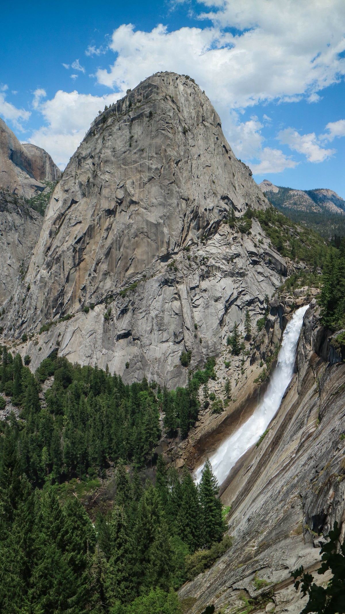 large mountain range with a narrow waterfall