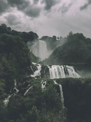 large rolling waterfall though a lush green hill