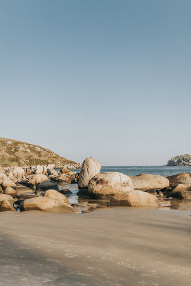 large round rocks scattered on a sandy beach