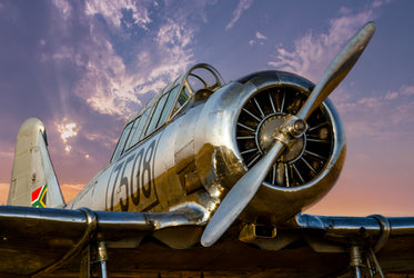 large silver plane at sunset with large propellers