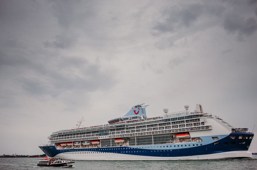 large white and blue cruise ship on a cloudy day