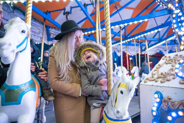 laughing girl and mom on carousel