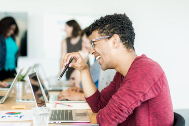 laughing man holding pen in meeting