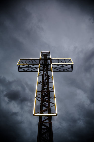 led lit cross against stormy sky