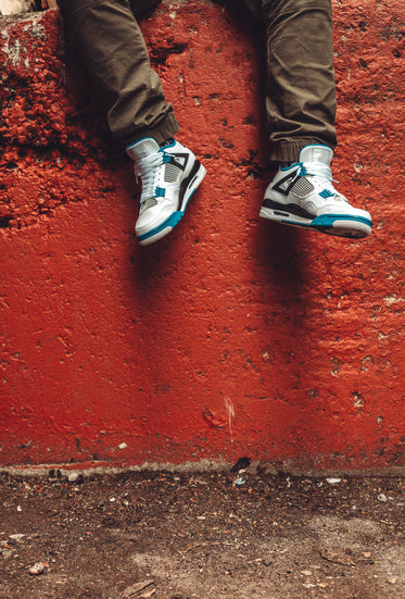 legs in front of red wall