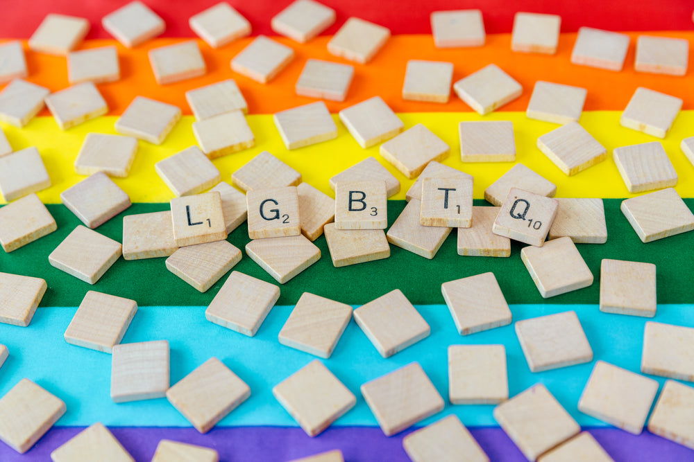 lgbtq letters in scrabble tiles over pride flag