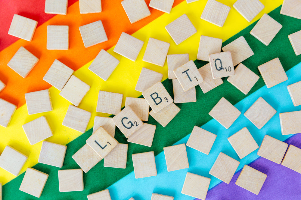 lgbtq letters tiles over pride flag angled