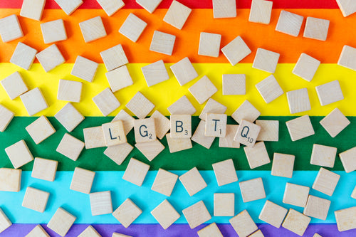 lgbtq scrabble letters over pride flag