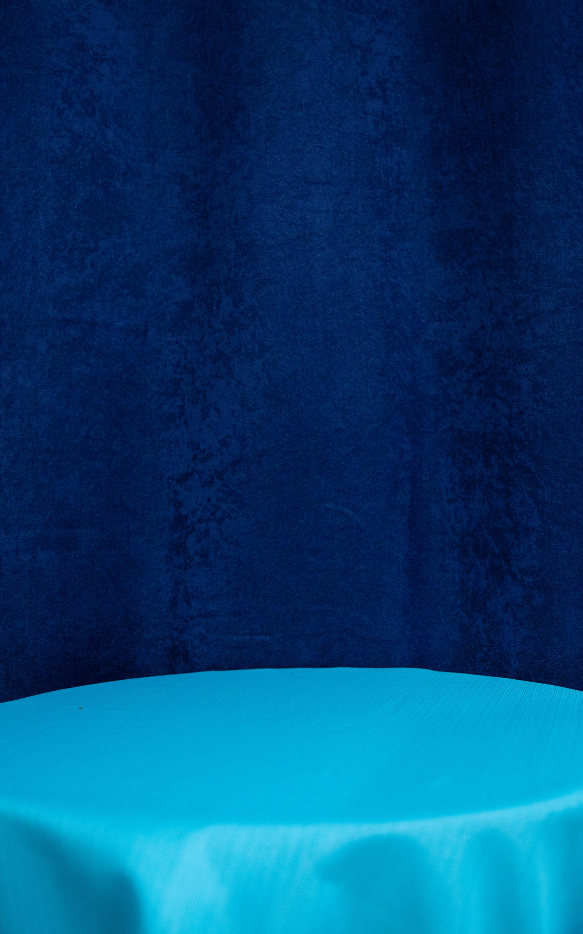 light blue round table with a dark blue backdrop