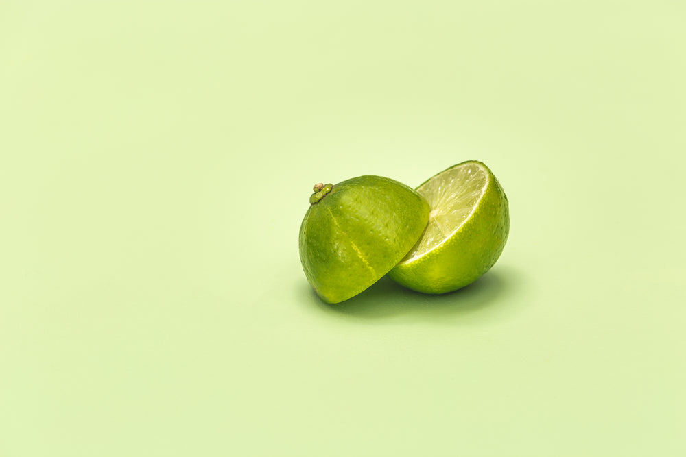 lime cut in half on green surface