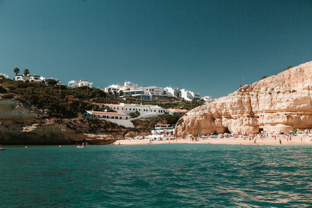 limestone hills peppered with houses overlook a sandy beach